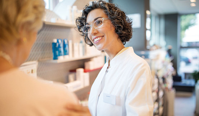 Lächelnde Apothekerin berät eine Kundin